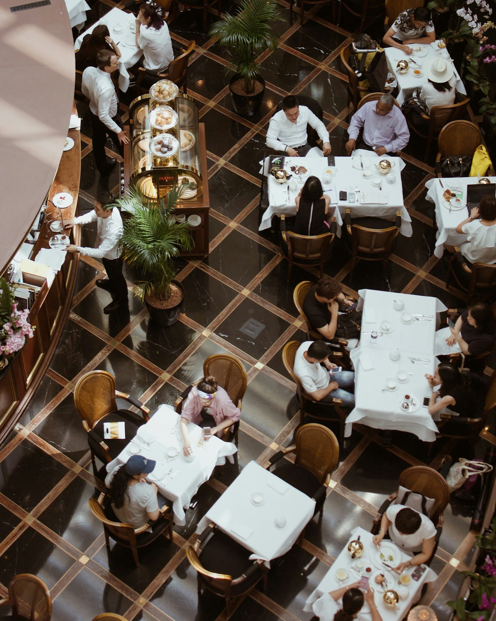 A restaurant floor seen from above, with tables laid out across a patterned floor