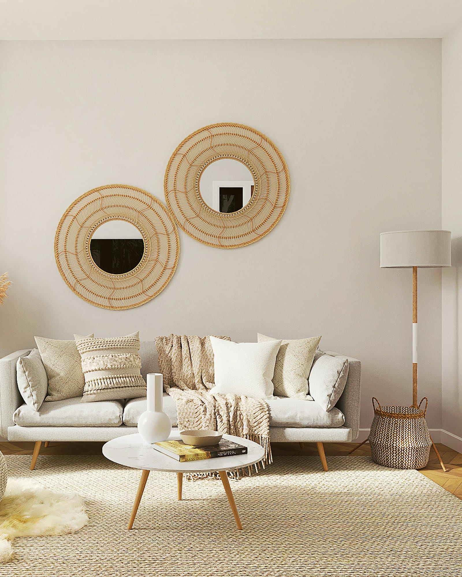 A cream living room with boucle armchairs, round rattan mirrors and dried grasses