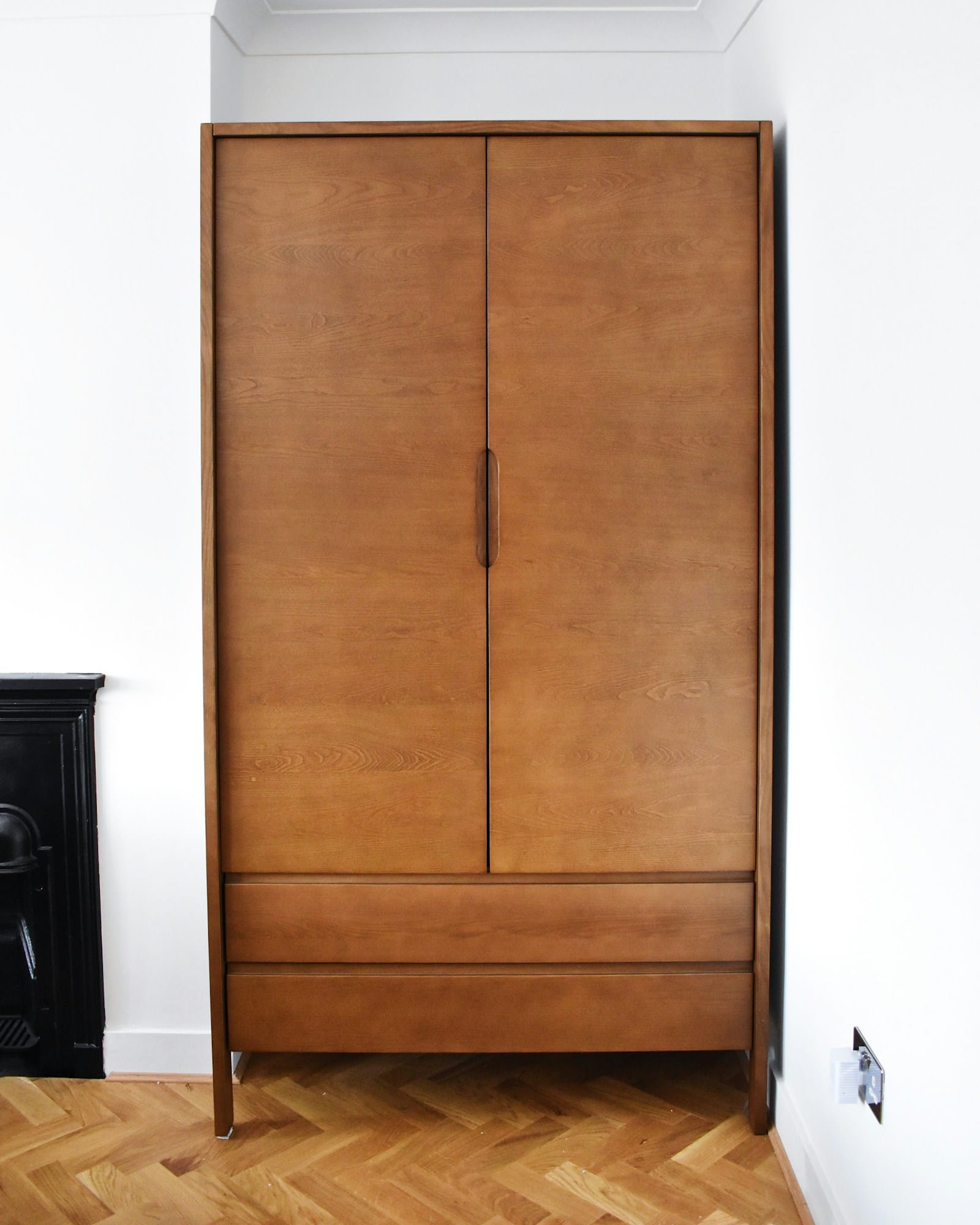 Tall double doors in warm timber veneer set flush into a plastered wall